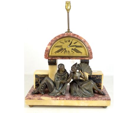 An Art Deco marble and onyx mantel clock and combination lamp with demi-lune dial set with Roman numerals above twin Pierrot 