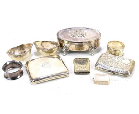 A group of silver items comprising two cigarette cases, two napkin rings, a pair of silver salts, an oval trinket box, a vest