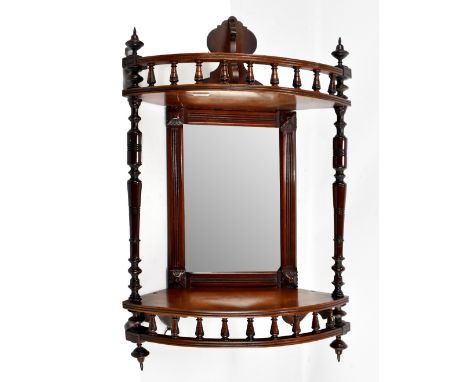 An Edwardian carved walnut hanging corner shelf with mirror back, height 52cm.