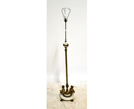 A Victorian brass standard lamp with cherubic figures to the base, height 145cm.