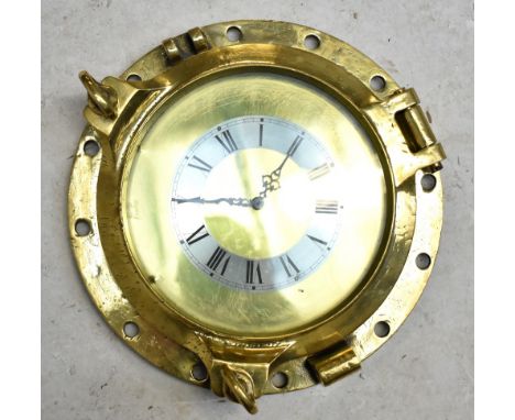 A brass ship's porthole, now converted into an electric wall clock, the silvered chapter ring set with Roman numerals, diamet