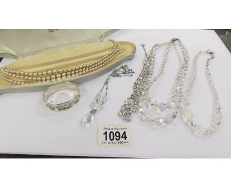 A triple row Lotus pearl necklace, 4 crystal necklaces and a silver napkin ring. (11 grams).