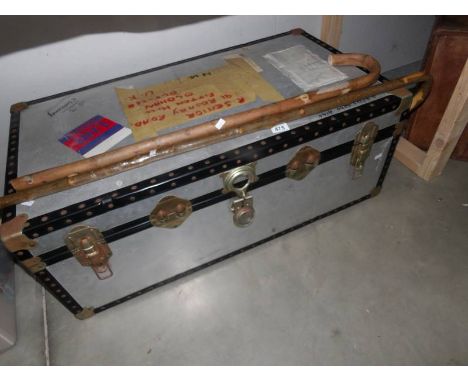 A large old trunk and 2 walking sticks.