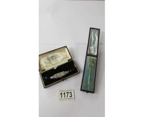 A cased gold/silver? stick pin featuring a stirrup and a cased art deco style wrist watch.