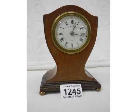 A small Maple &amp; Co., inlaid mantel clock on brass ball feet, in working order.
