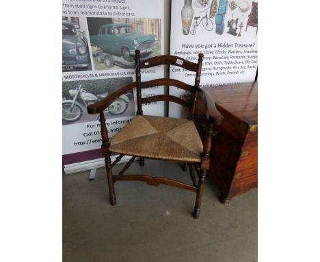 A 19th century country ladder back chair with rush seat on ringed turned legs, double side stretchers with comb front stretch