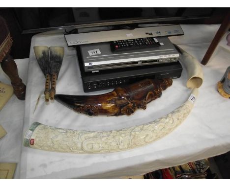 A replica resin carved tusk, a wind instrument made from cow horns and an unusual gatorade horn bottle.