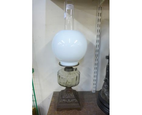 An oil lamp with metal base and glass reservoir