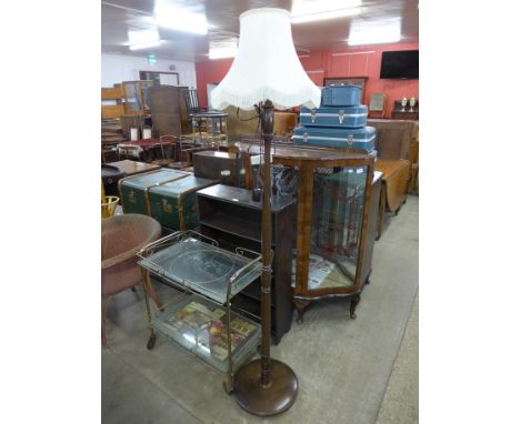 A walnut display cabinet, trolley, standard lamp and an open bookcase