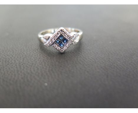 A sapphire and diamond dress ring - The square-shape sapphire panel within a brilliant-cut diamond surround and crossover sho