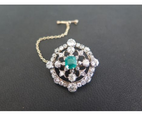 An early to mid 20th century silver and gold emerald and diamond brooch - The octagonal emerald, within an old-cut diamond su