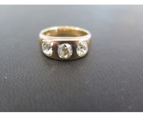 An early to mid 20th century 18ct gold diamond three-stone ring - The old-cut diamonds inset to the plain band - Estimated to