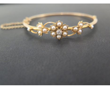 An early 20th century old-cut diamond and seed pearl pearl hinged bangle - Of foliate design - Tests as higher carat gold - I