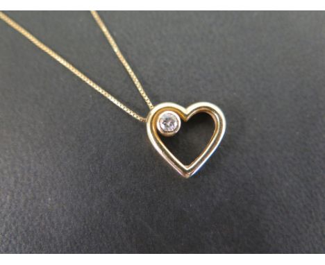 An 18ct gold open heart pendant with brilliant-cut diamond collet - Suspended from a box-link chain - Estimated diamond weigh