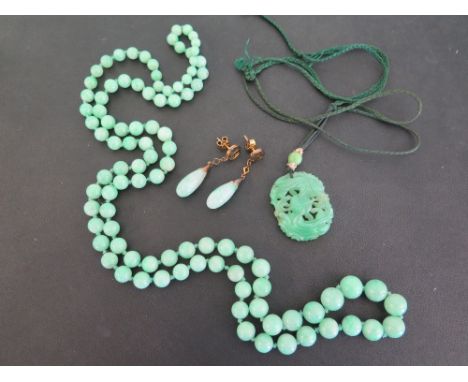 A pair of jade ear pendants - Stamped K18 - Length 4cms - Weight approx 6.0gms  - A carved jade panel pendant, with seed pear