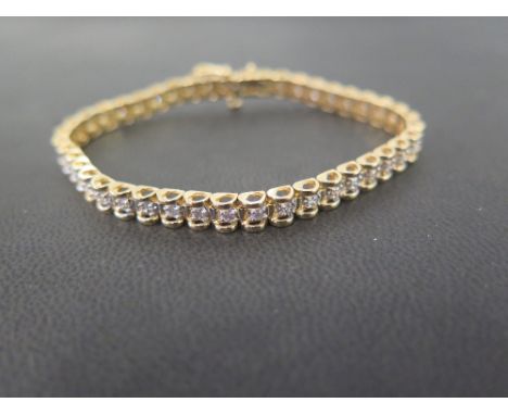 A bi-colour brilliant-cut diamond line bracelet - Estimated total diamond weight 1.20cts - Stamped 14K - Length 17.5cms - Wei
