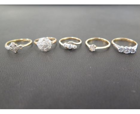 Five diamond set rings - To include a single-stone - Two three-stones - A cluster and a dress ring - Four stamped 18ct and pl