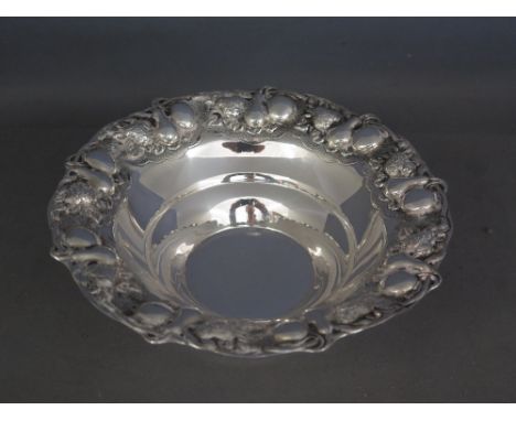 A pretty sterling silver three footed bowl the rim decorated with vines and fruit - Greek hallmarks and stamped 925 - Diamete