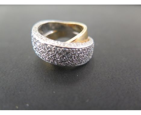 A diamond crossover ring - Of bi-colour design, the pave-set diamond band to the plain band - Stamped 750 - Ring size L 1/2 -