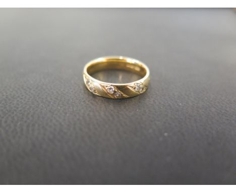 An 18ct gold diamond-set band ring - Hallmarked London - Ring size K - Weight approx 3.9gms 
Condition Report: Good - With li