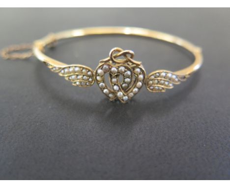 A late 19th/early 20th century 9ct gold seed pearl love heart hinged bangle - Inner diameter 6cms - Weight approx 6.1gms
Cond