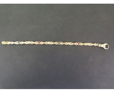 A sapphire and ruby panel bracelet - The alternating circular cabochons to the cross links - Stamped 750 - Length 18.5cms - W