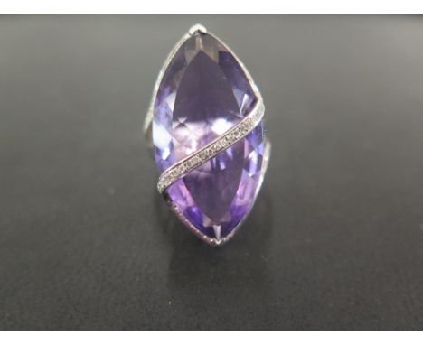 An amethyst and diamond statement ring - The kite-shape amethyst to the brilliant-cut diamond curved lines, openwork shoulder