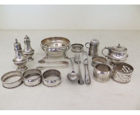 A mixed quantity of hallmarked silver including knife, fork, spoon, napkin rings, salt, peppers, mustard etc. - Weight approx