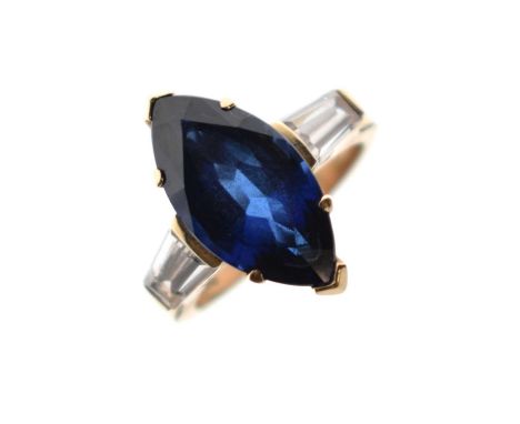 Synthetic sapphire and white stone yellow metal dress ring, the marquise shaped blue stone measures 8.5mm x 16mm approx, the 
