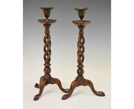 Pair of walnut candlesticks, circular drip pan over open double helix column, raised on tripod base, 40cm high (2)