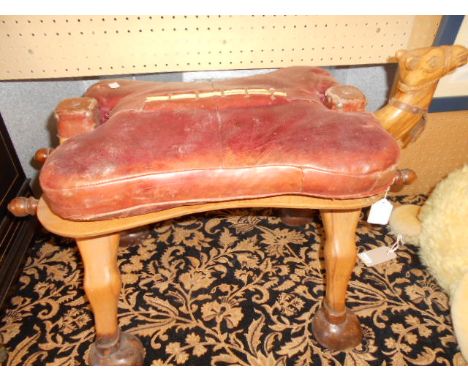 A mid-20th C camel saddle stool with leather seat