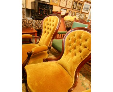 A pair of Victorian rosewood framed his and her salon chairs, each with spoon shaped button back, serpentine overstuffed seat