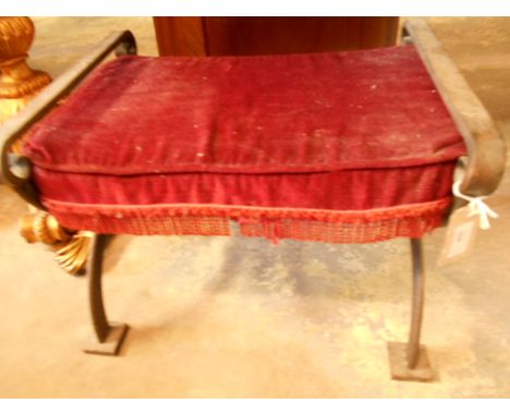 A 20th C scrolling wrought iron x-frame stool with red upholstered cushion seat