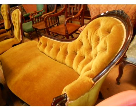 A Victorian rosewood framed chaise longue with spoon shaped button back over a serpentine seat raised on scrolling floral car