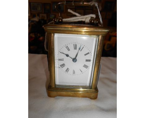 A miniature French brass and glass carriage clock in need of attention