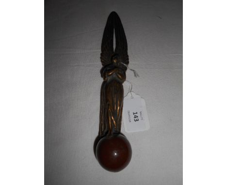 A 19th C brass letter opener in the form of an angel surmounted on a ceramic orb