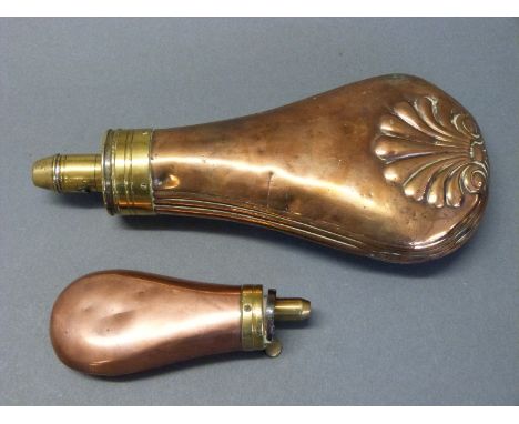 Two copper and brass powder flasks one with embossed shell decoration stamped 'patent', 19.5cm long, the other a pistol flask