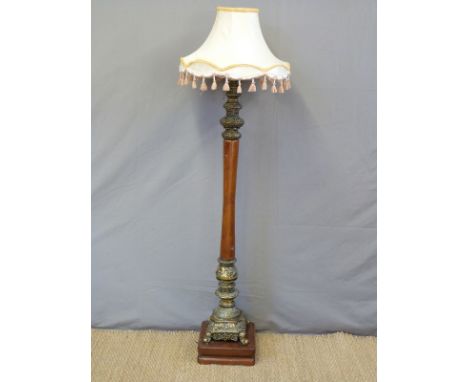An ornate brass and mahogany standard lamp the brass sections depicting horses and rococo swags 