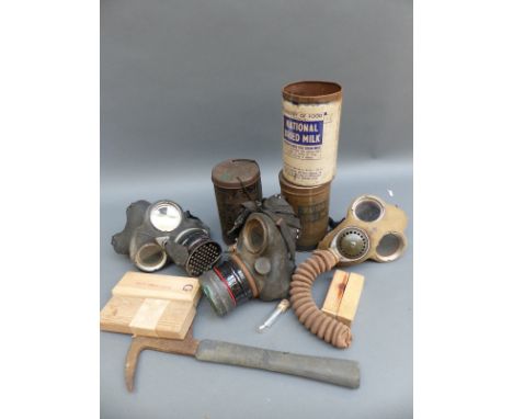 A quantity of gas masks, one dated 5/5/41, escape axe, Ministry of Food dried milk tins etc