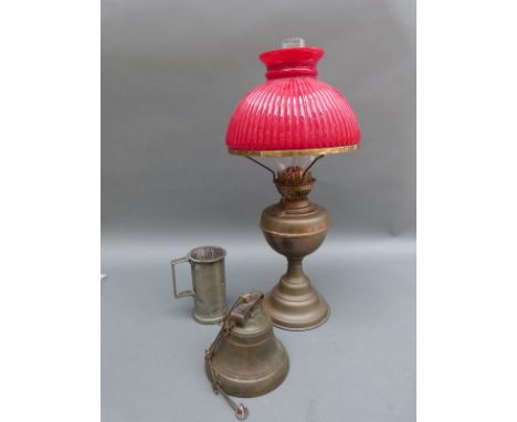 A brass oil lamp with red glass shade, a brass bell and a pewter tankard 