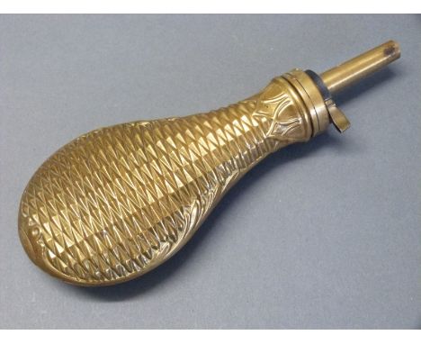 An all brass powder flask with embossed geometric decoration to both sides and acanthus leaf border, 22cm long. 