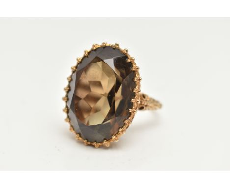 A LARGE SMOKY QUARTZ DRESS RING, large oval cut smoky quartz, approximate length 25mm x width 18mm, prong set in yellow gold,