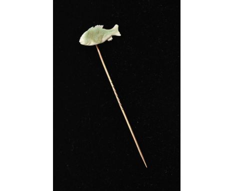 A YELLOW METAL MOTHER OF PEARL STICK PIN, set with a carved mother of pearl fish, to a yellow metal pin, unmarked, length 70m