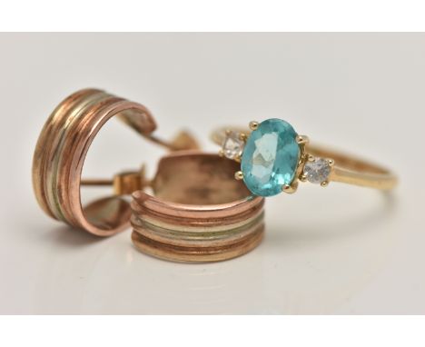 A 14CT GOLD RING AND A PAIR OF HOOP EARRINGS, the ring set with a central oval cut light blue stone, flanked with circular cu