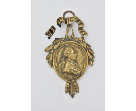 A LATE 19TH CENTURY BRASS WALL HANGING HOOK, cast with a ribbon and wreath above an oval side profile portrait of a late 18th