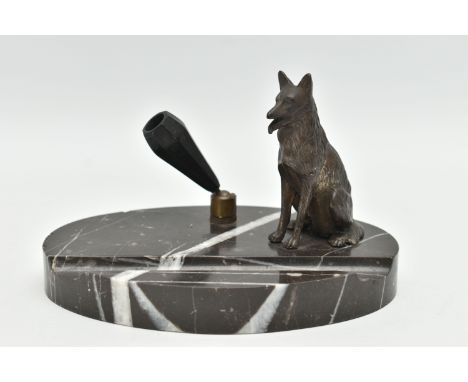 AN ART DECO OVAL MARBLE BASED PEN HOLDER, fitted with a black bakelite pen holder in a ball socket and a seated Alsatian, ova