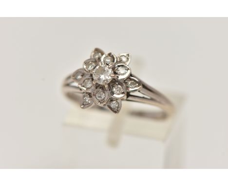 A WHITE METAL DIAMOND CLUSTER RING, of a flower shape, set with a central round brilliant cut diamond, within a surround of s