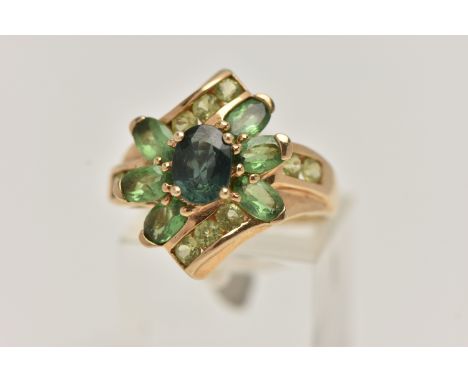 A 9CT GOLD GEM SET RING, dress ring set with a central oval cut green sapphire, within a surround of oval cut green garnets a