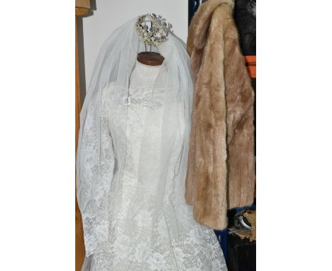 A 1970S IVORY WEDDING DRESS AND VEIL, comprising a layered tulle skirt and fitted bodice, Princess line with floral lace over