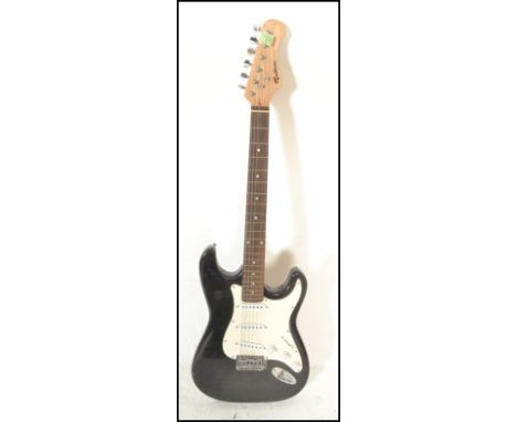 A vintage Rockburn electric six string guitar. The black body having white scratch guard with chrome tuning pegs and mother o